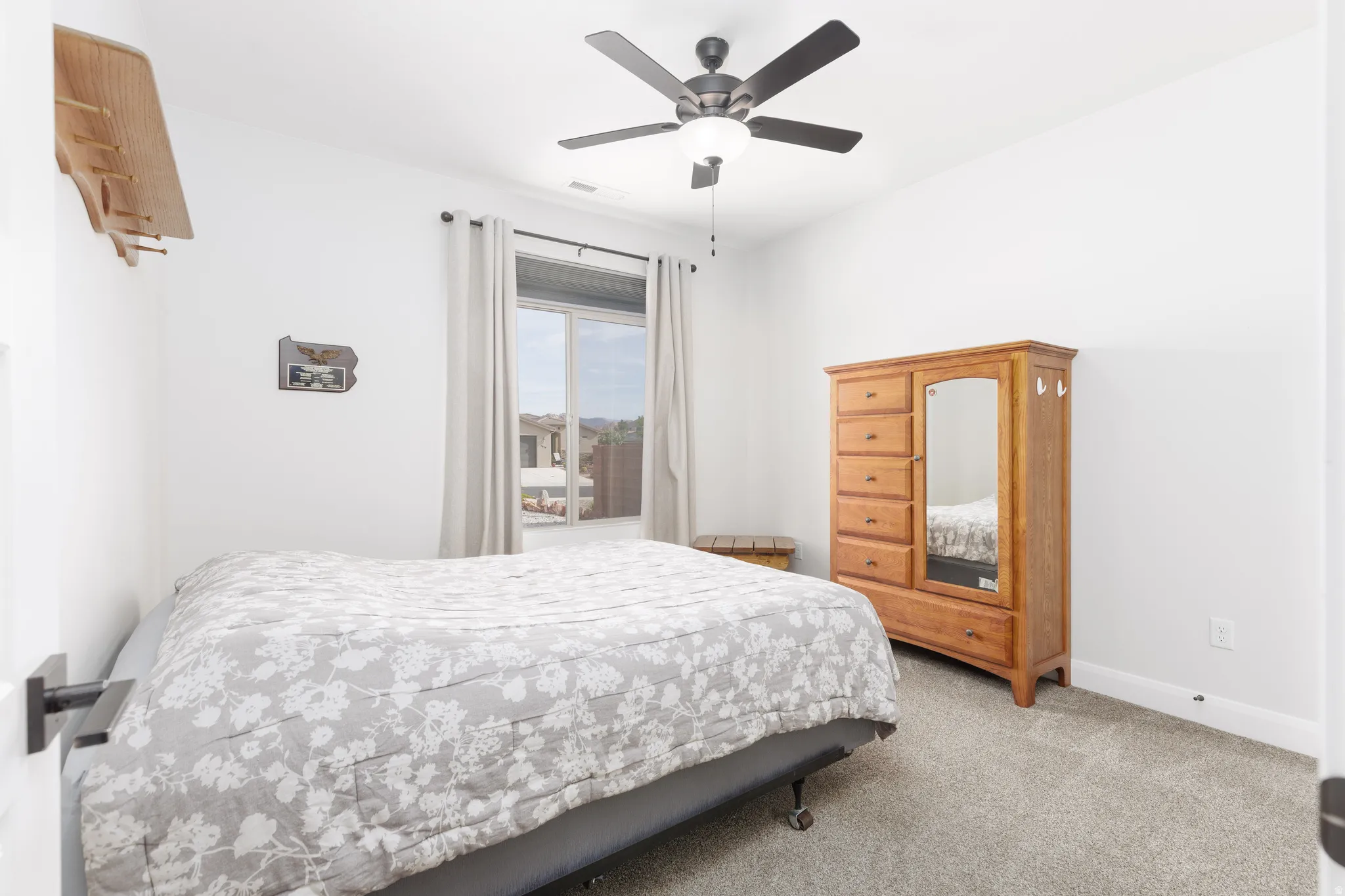 Carpeted bedroom with ceiling fan and baseboards