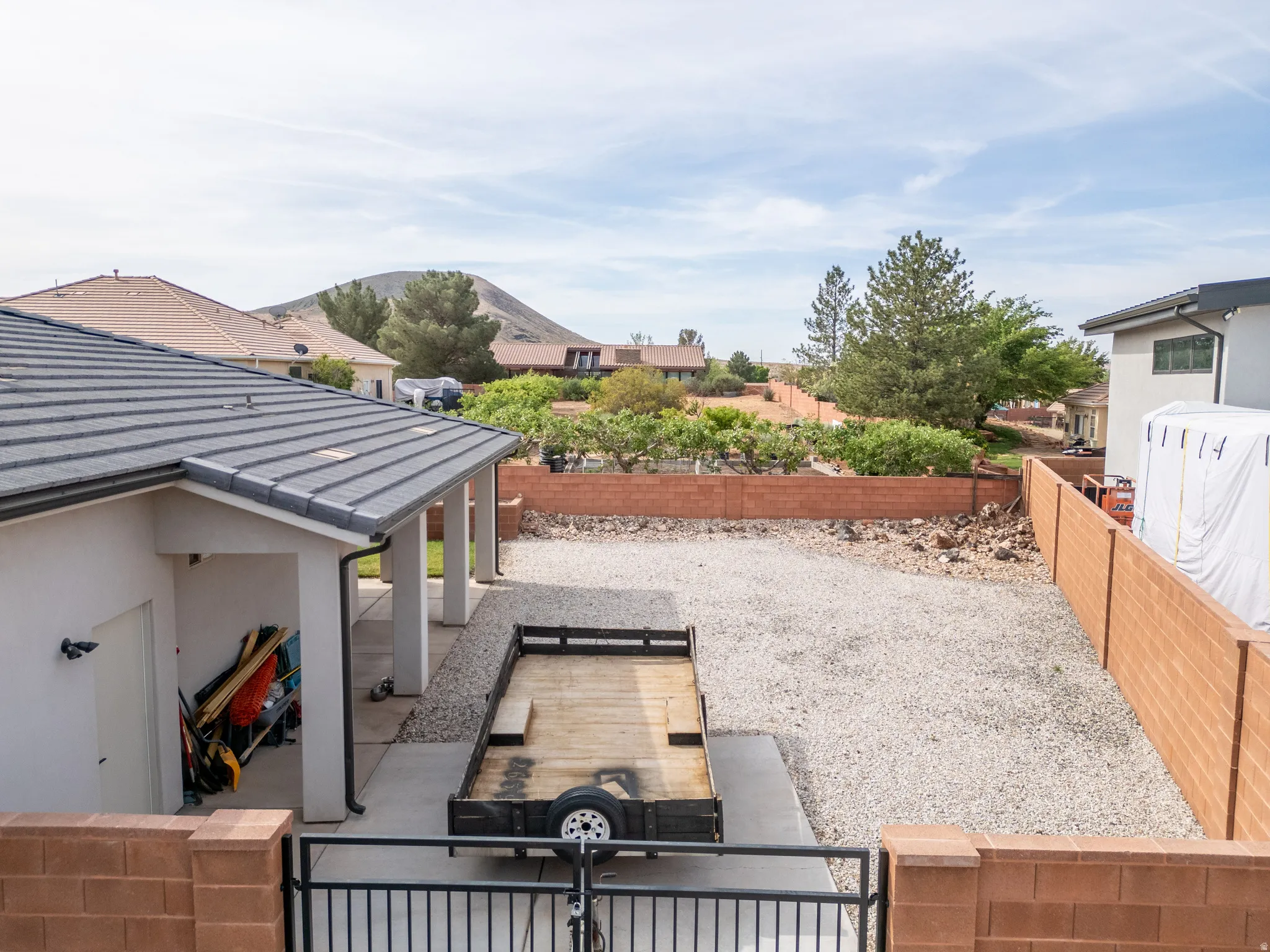 Fenced backyard with a patio area, a gate, and a residential view