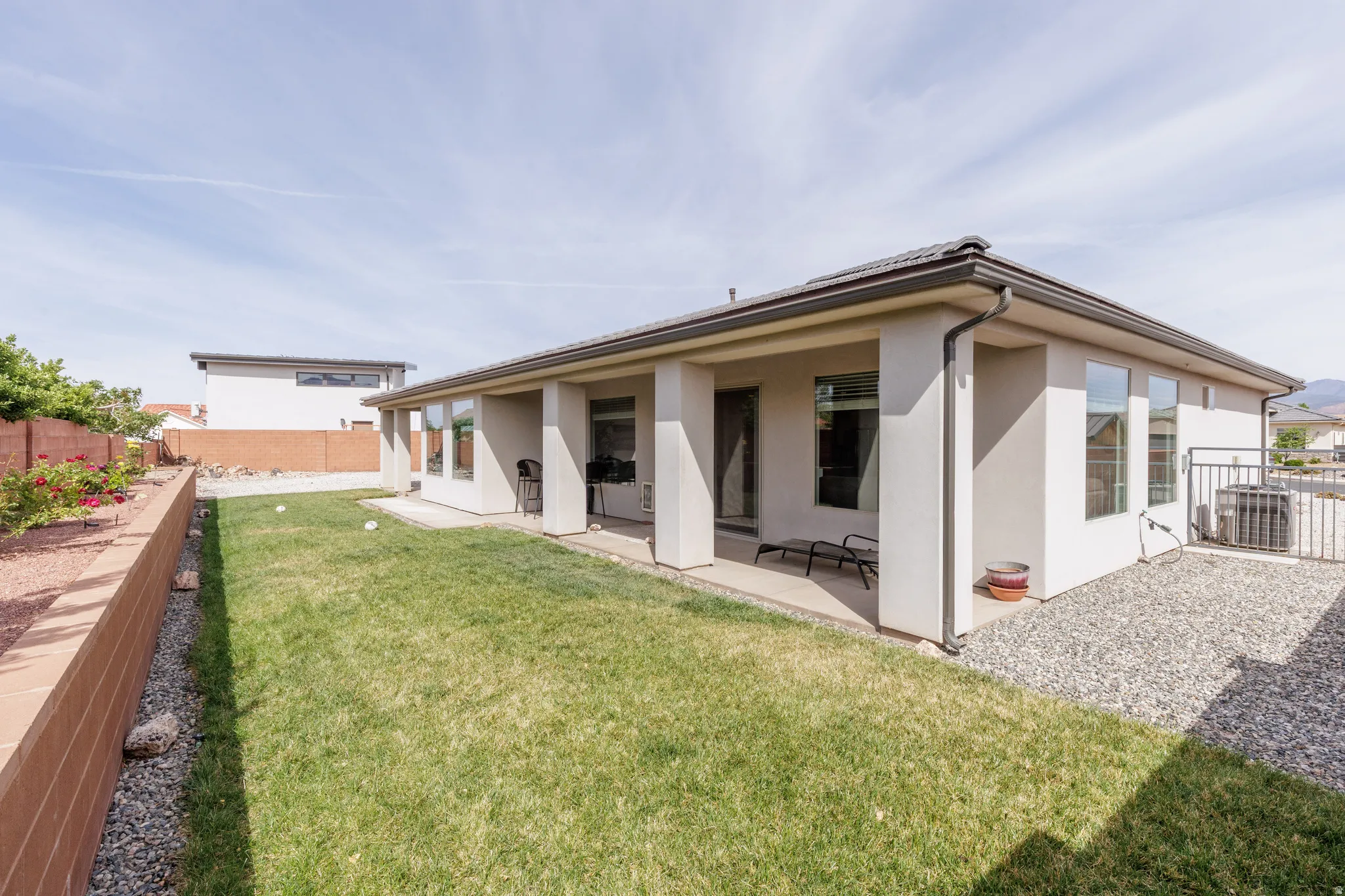 Back of property with a fenced backyard, stucco siding, and a patio area