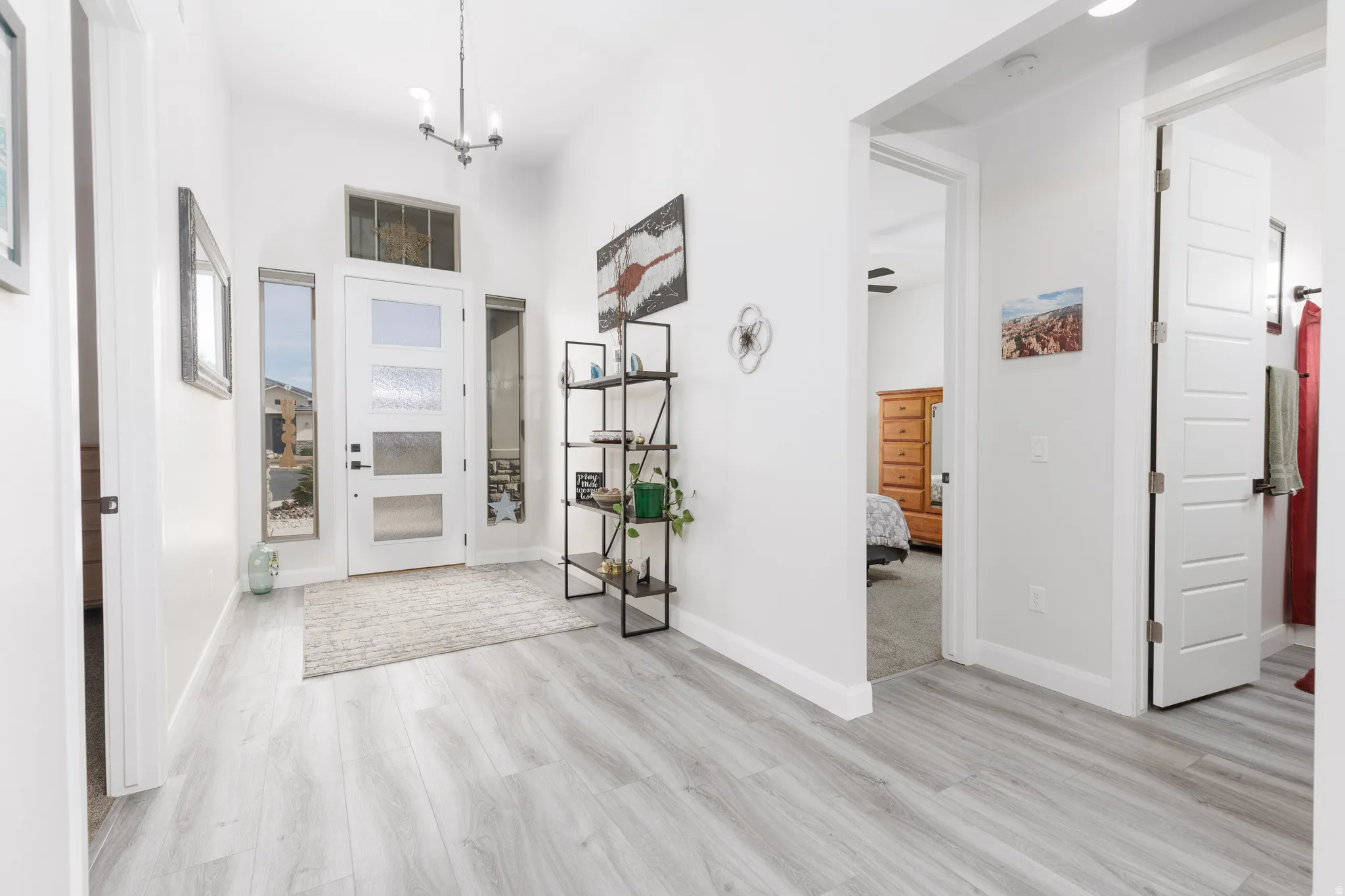 Entryway with a chandelier, light wood-style flooring, and a high ceiling