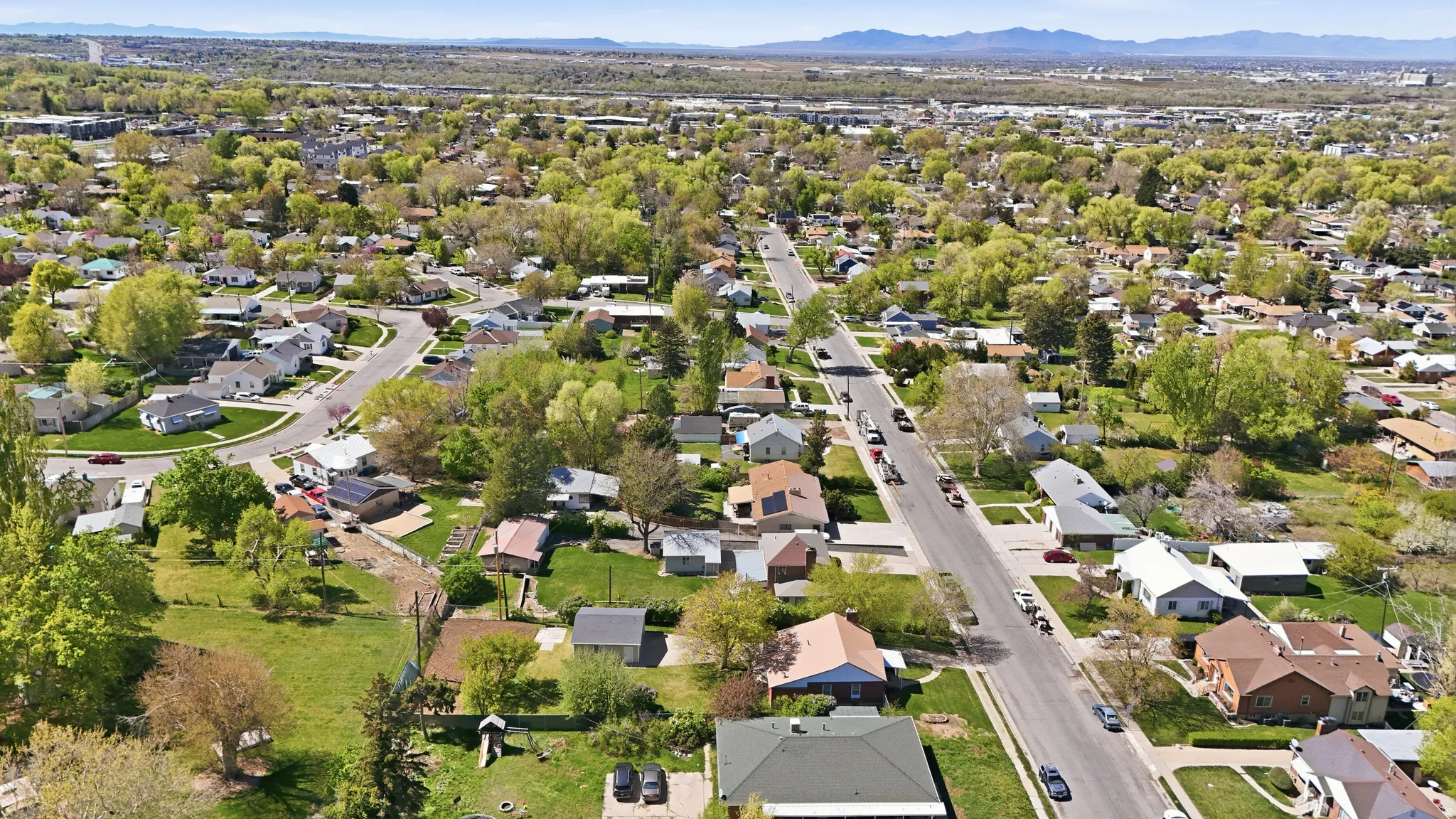 Aerial view of property and surrounding area with a mountainous background and nearby suburban area