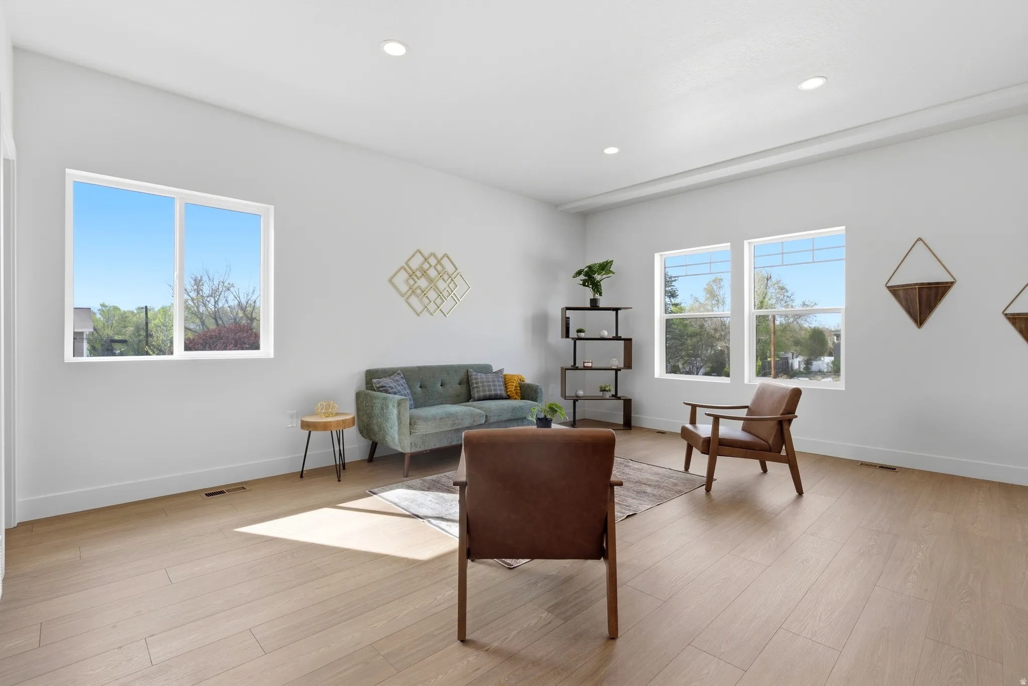 Living room with light wood finished floors and recessed lighting