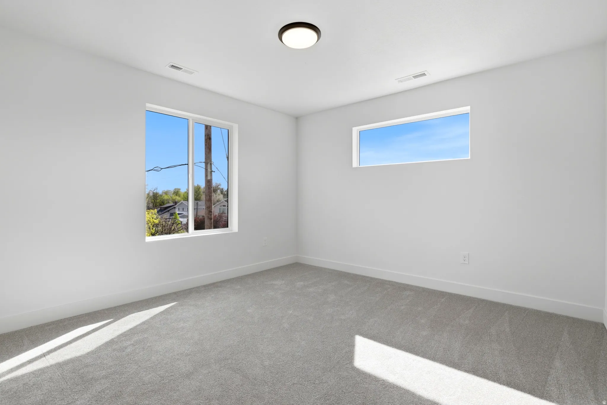 Carpeted empty room featuring plenty of natural light