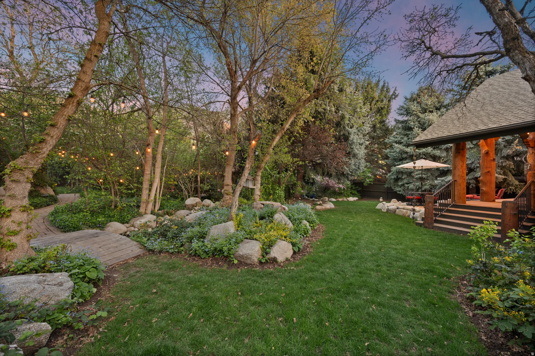 Yard at dusk with a lawn and view of scattered trees