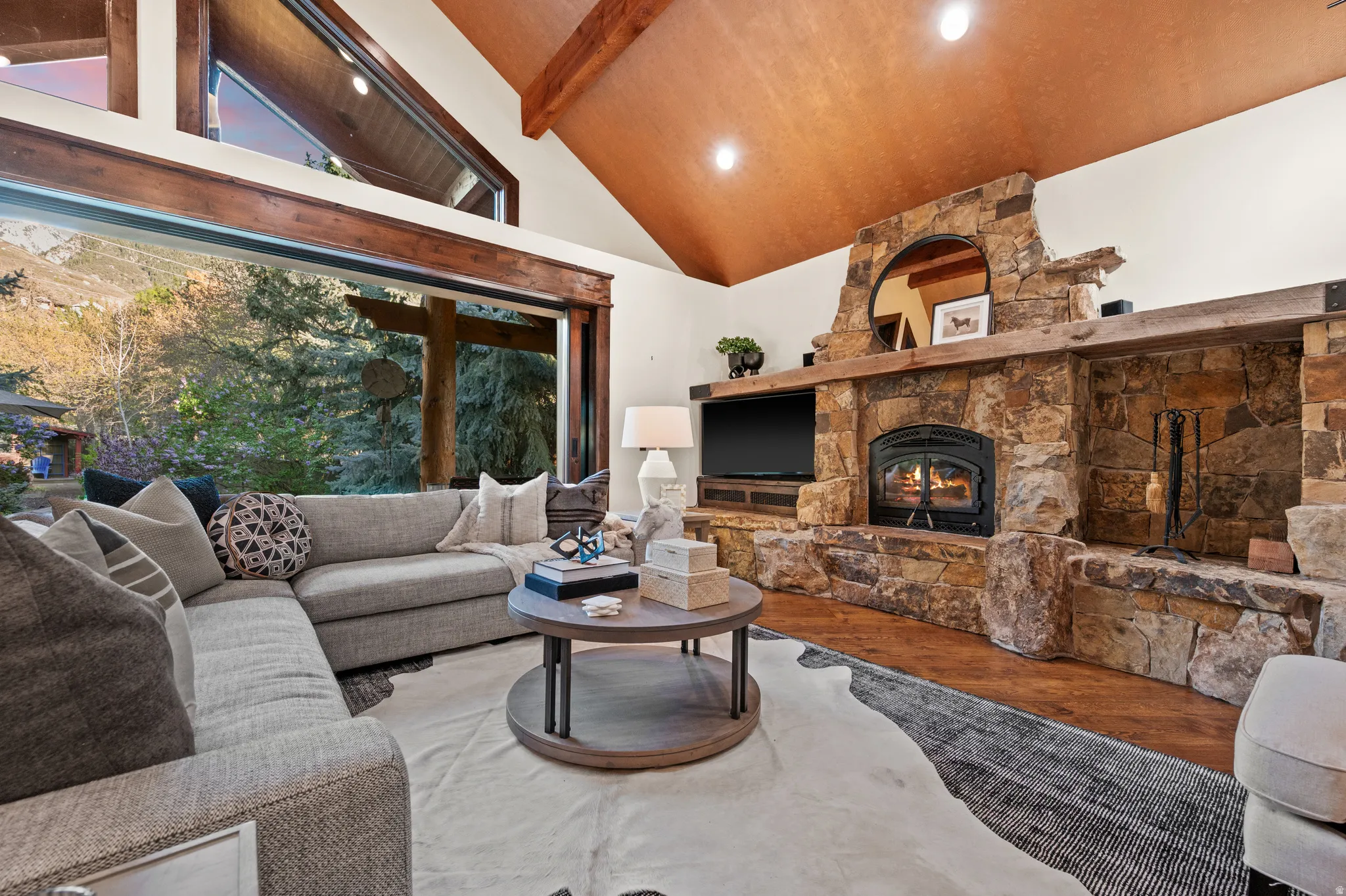 Living room with wood finished floors, lofted ceiling, a fireplace, and recessed lighting