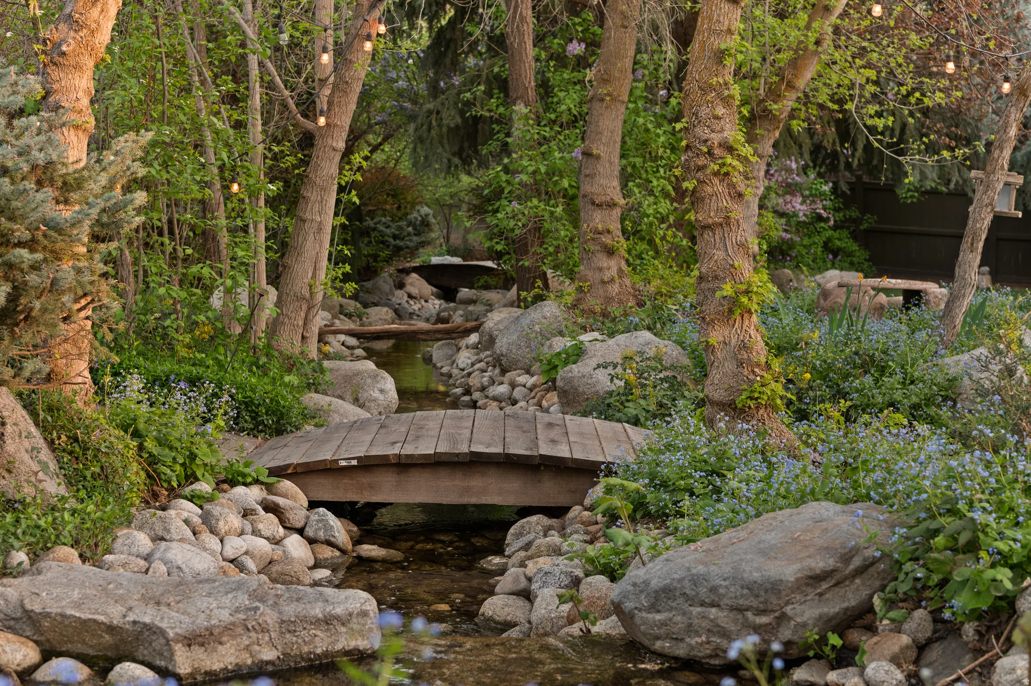 View of private river and bridge located inside fenced backyard