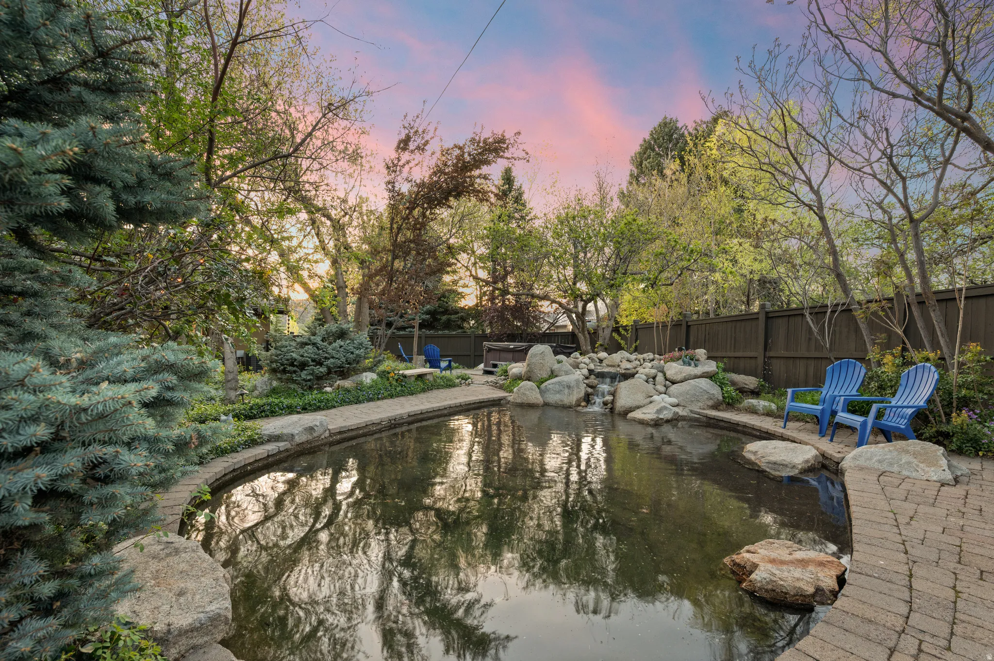 View of  garden pond, a fenced backyard, and patio surround
