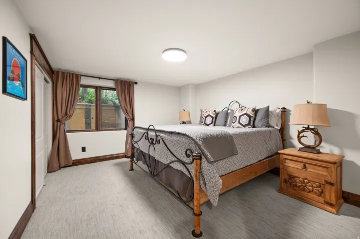 Bedroom with baseboards and light carpet