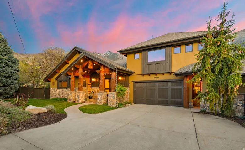 View of front of home featuring roof with shingles, concrete driveway, a garage, stone siding, and stucco siding