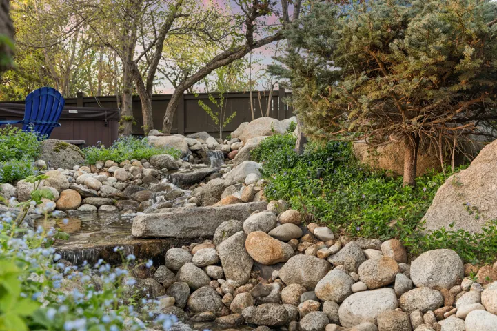 View of private river and bridge located inside fenced backyard