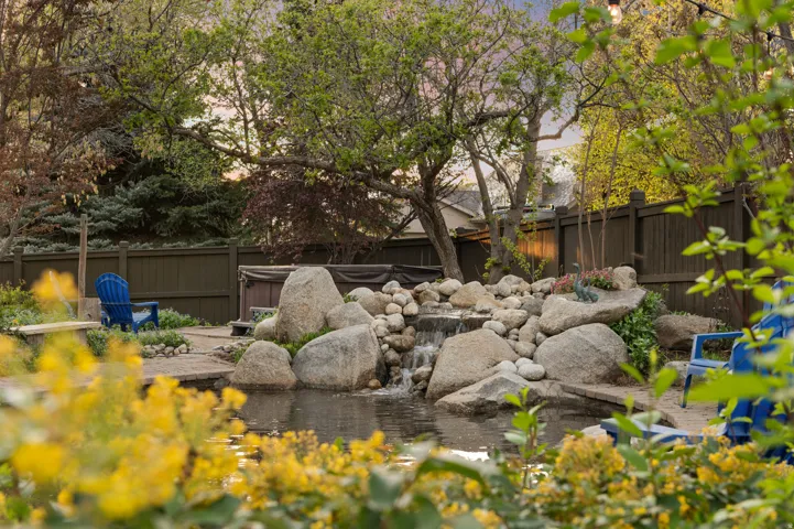 Fenced backyard with a small pond