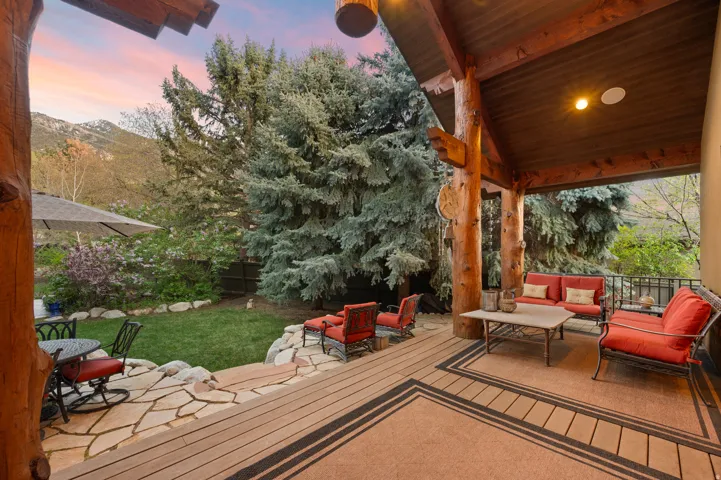 Wooden deck with a patio, an outdoor hangout area, and a fenced backyard