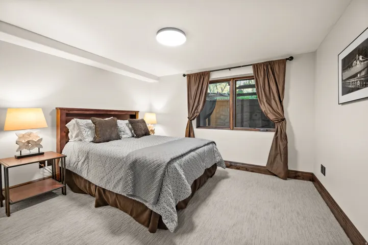 Bedroom with baseboards and light colored carpet