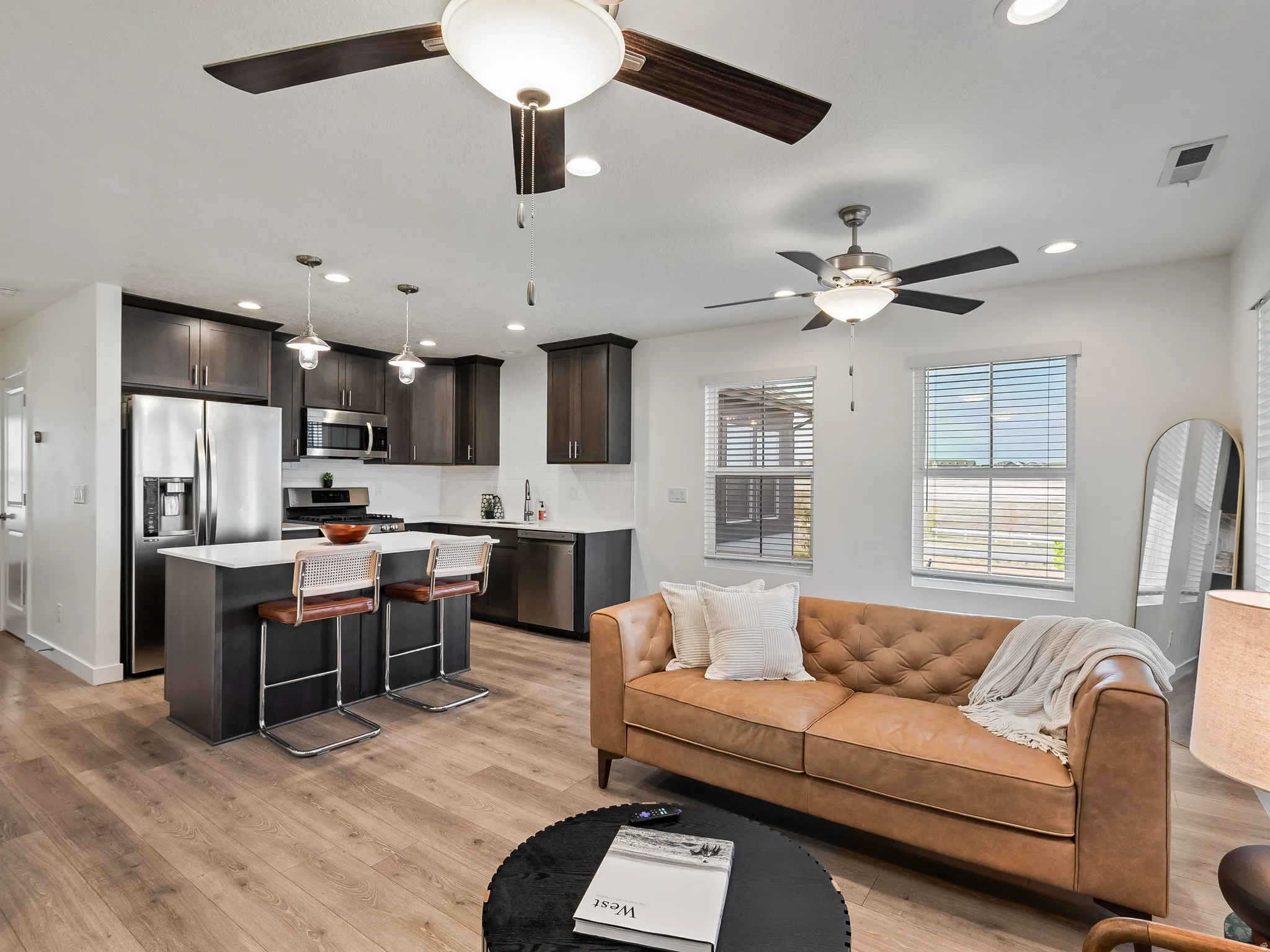 Living room with light wood finished floors, recessed lighting, and ceiling fan