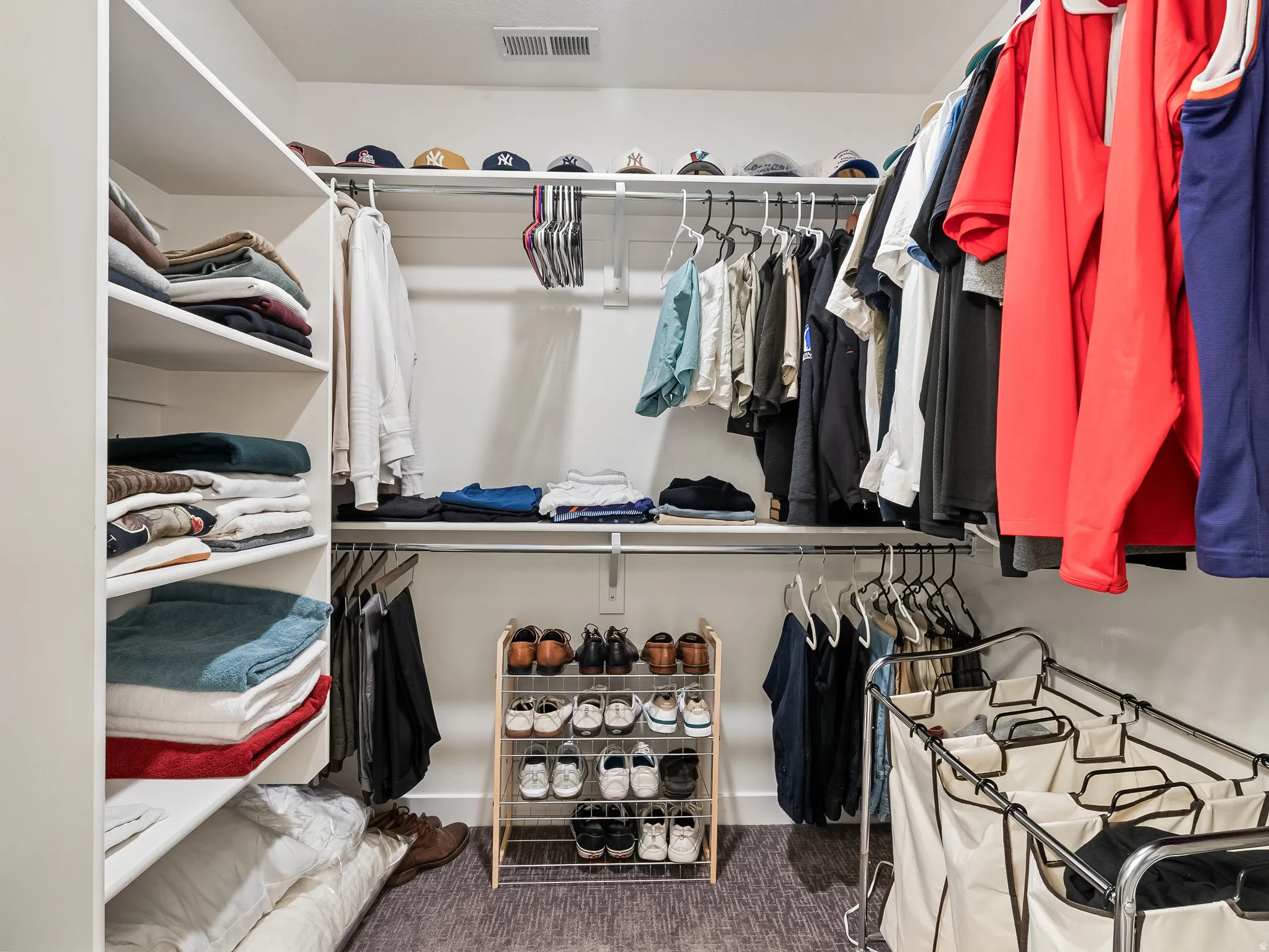 Walk in closet featuring dark carpet