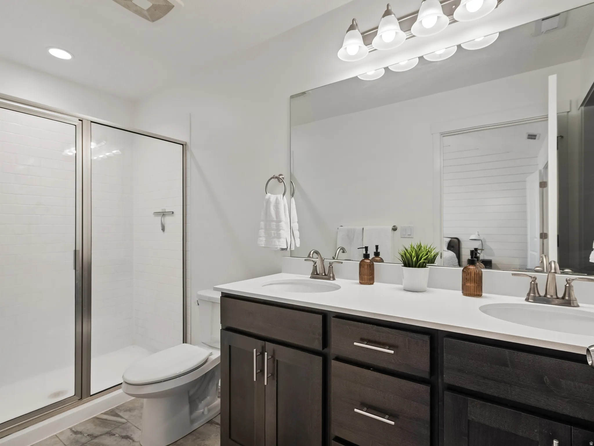 Bathroom featuring double vanity and a stall shower