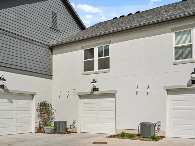 View of side of home with stucco siding and concrete driveway
