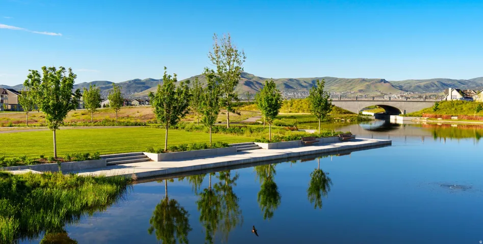 Water view with a floating dock, a mountain backdrop, and a notable bridge