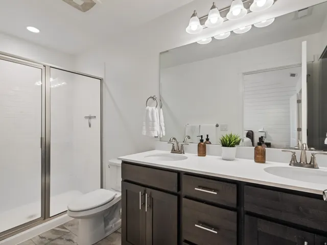 Bathroom featuring double vanity and a stall shower