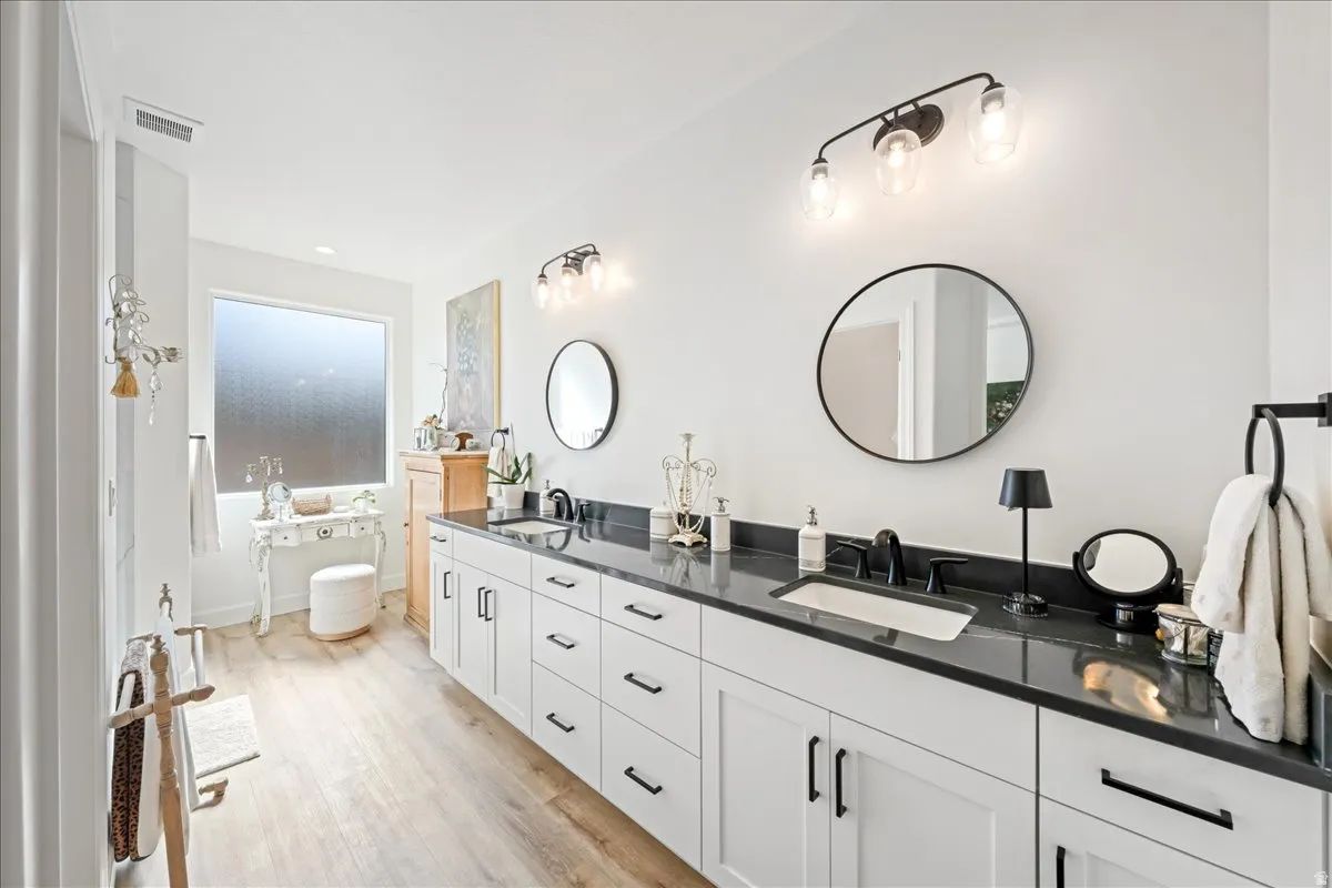 Bathroom featuring double vanity and light wood-style flooring