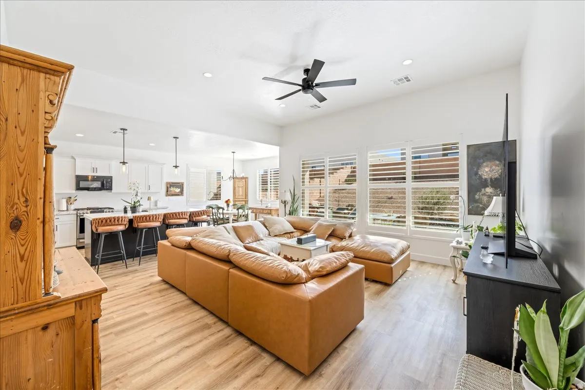 Living room featuring light wood-style flooring, a ceiling fan, and recessed lighting