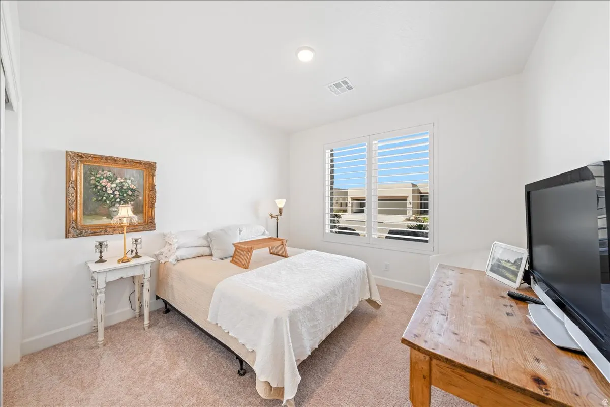 Bedroom with baseboards and light colored carpet