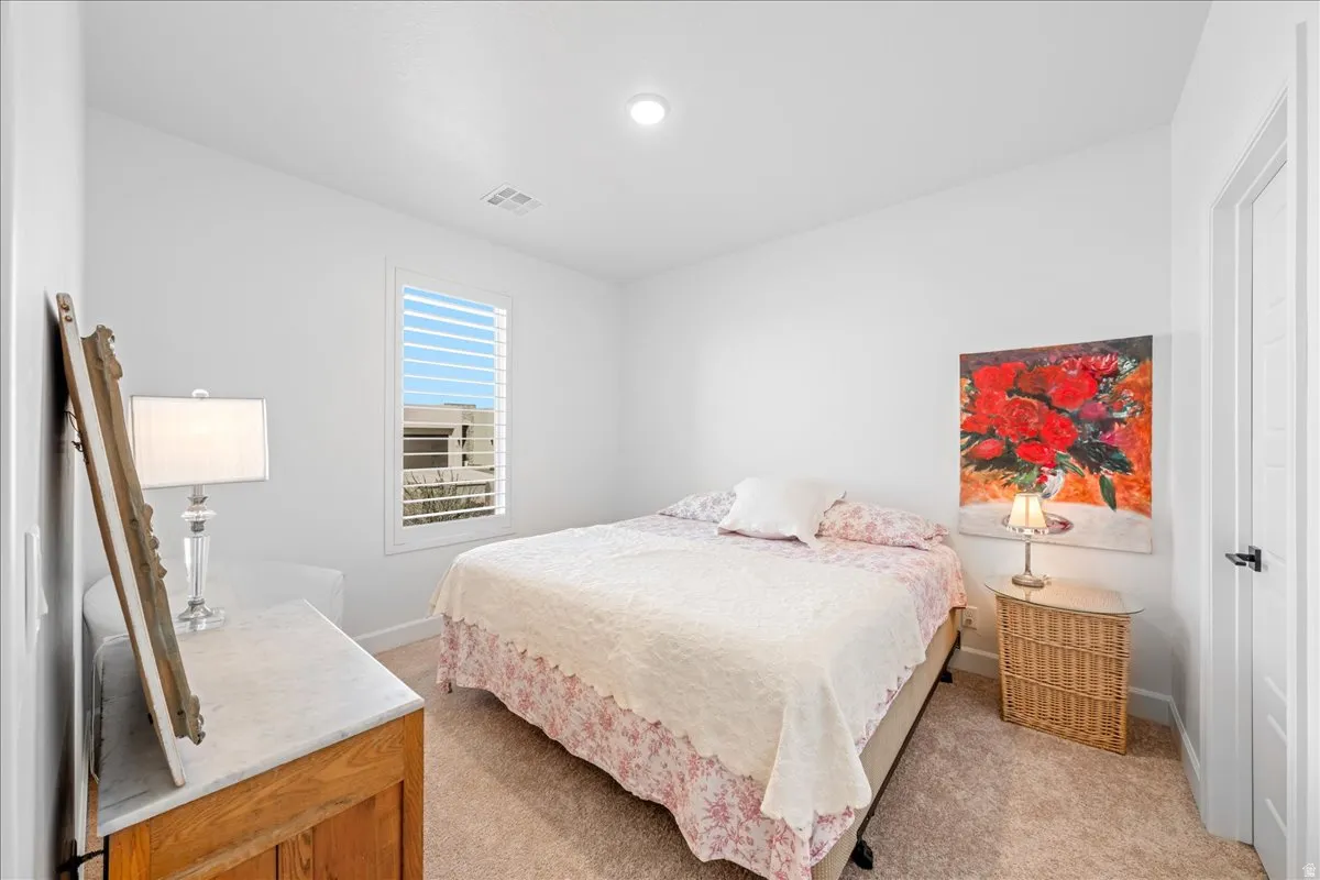 Bedroom featuring baseboards and light colored carpet
