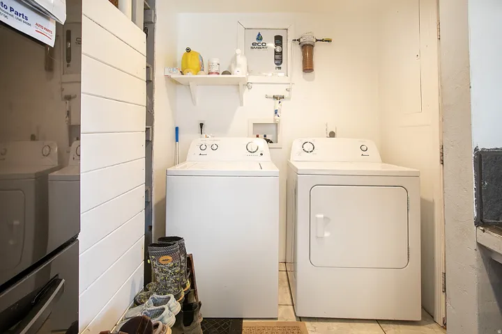 Laundry area with separate washer and dryer and light tile patterned flooring