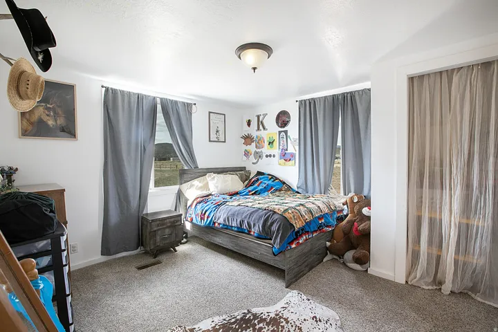 Bedroom featuring light carpet and baseboards