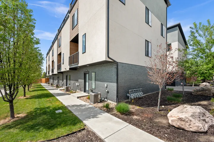 View of side of home featuring brick siding, a lawn, and stucco siding