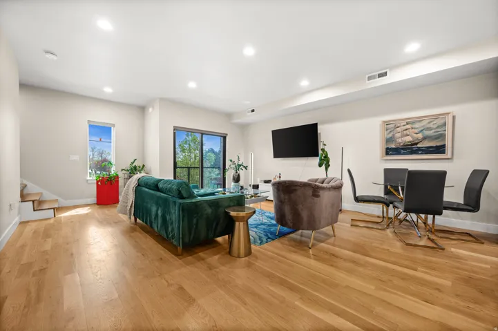 Living area with light wood-type flooring and recessed lighting