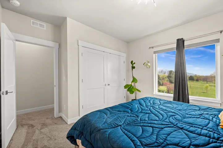 Primary Suite Bedroom featuring light colored carpet and a closet