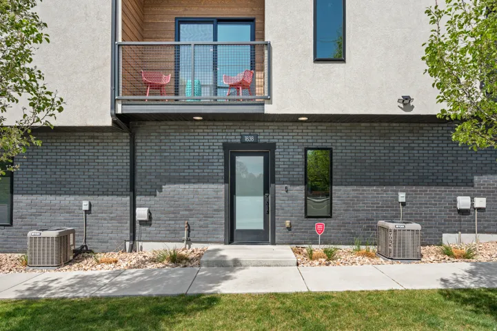 Entrance to property featuring brick siding, stucco siding, and a lawn