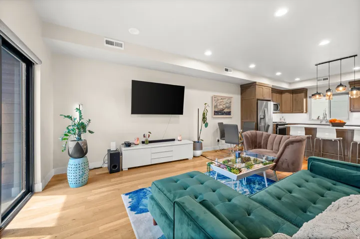 Living area with light wood-type flooring and recessed lighting