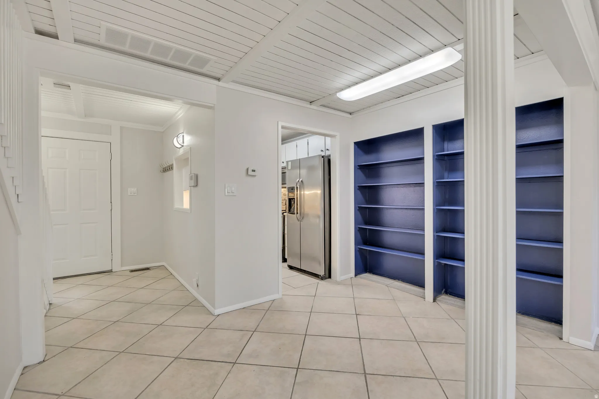 Hallway with baseboards and light tile patterned floors