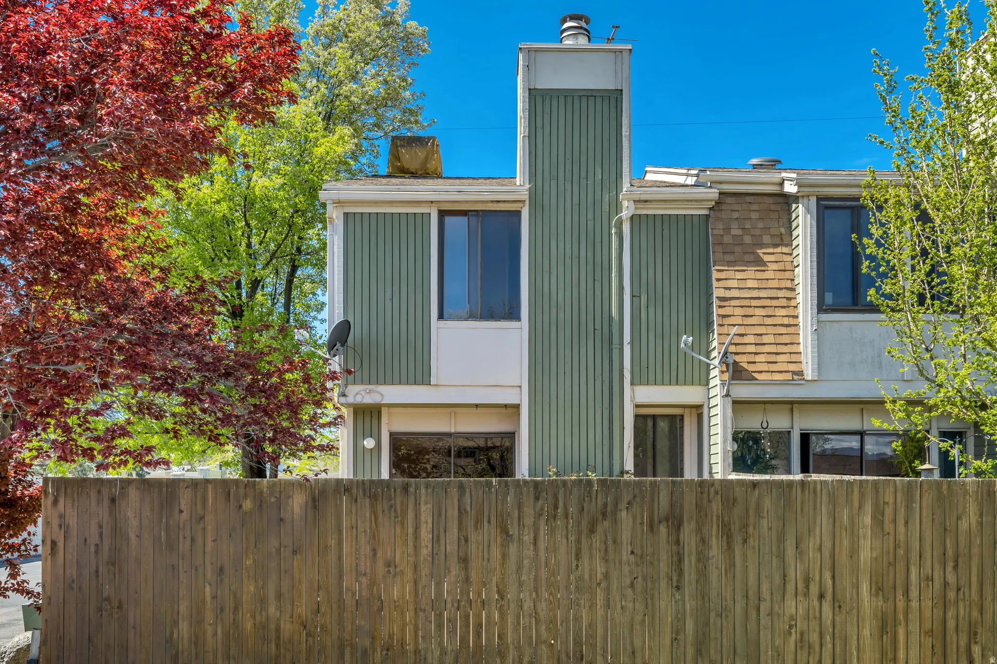Back of property with a fenced front yard and a chimney