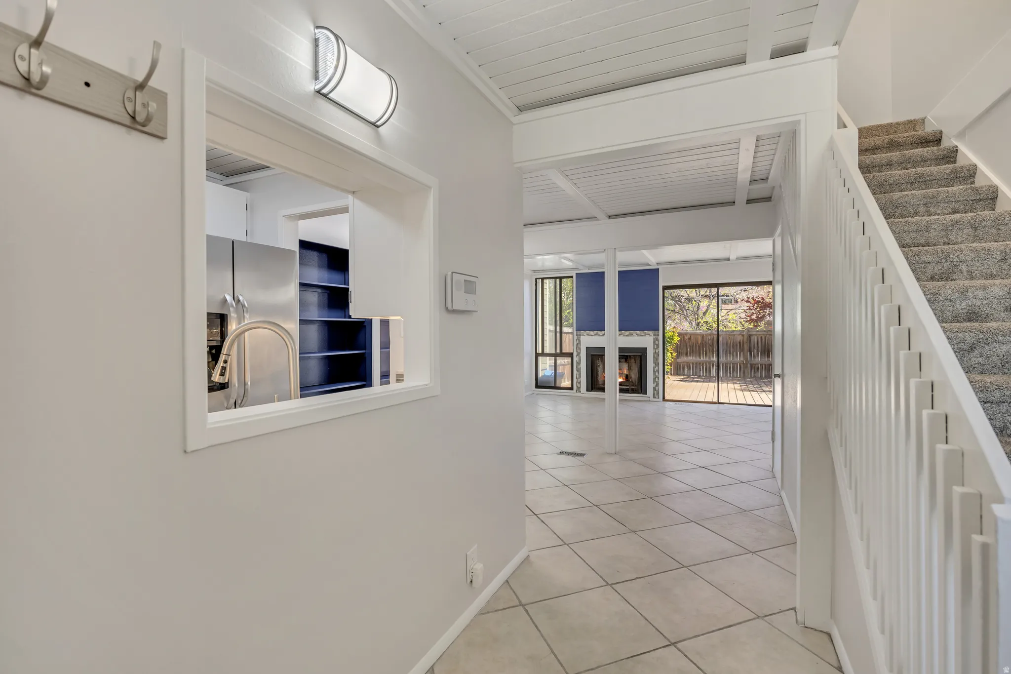 Corridor featuring light tile patterned flooring and baseboards