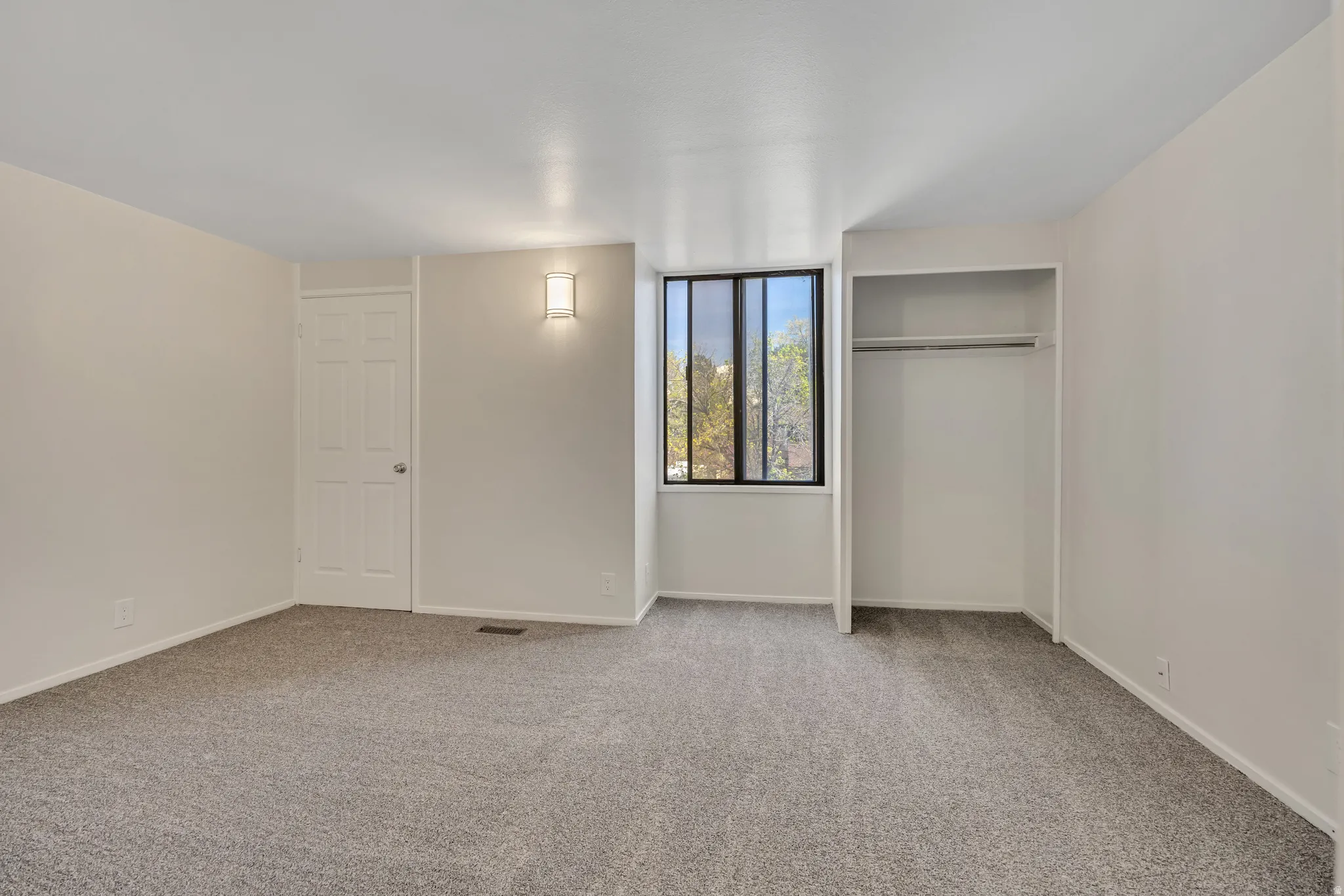 Unfurnished bedroom with carpet floors and baseboards