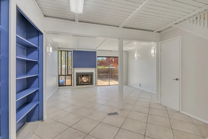 Unfurnished living room with a lit fireplace and light tile patterned flooring