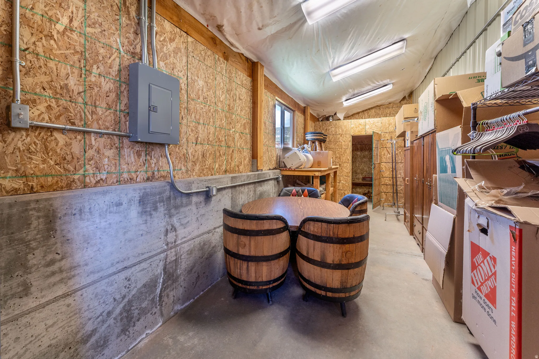 Miscellaneous room featuring concrete floors, electric panel and storage area