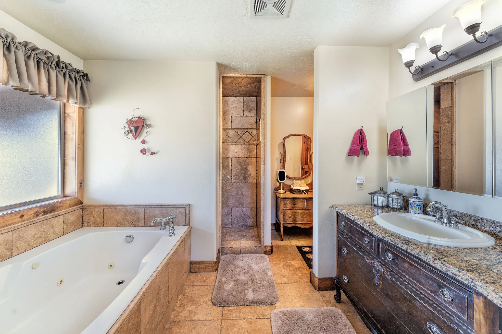 Full bath featuring vanity, walk in shower, and a tub with jets