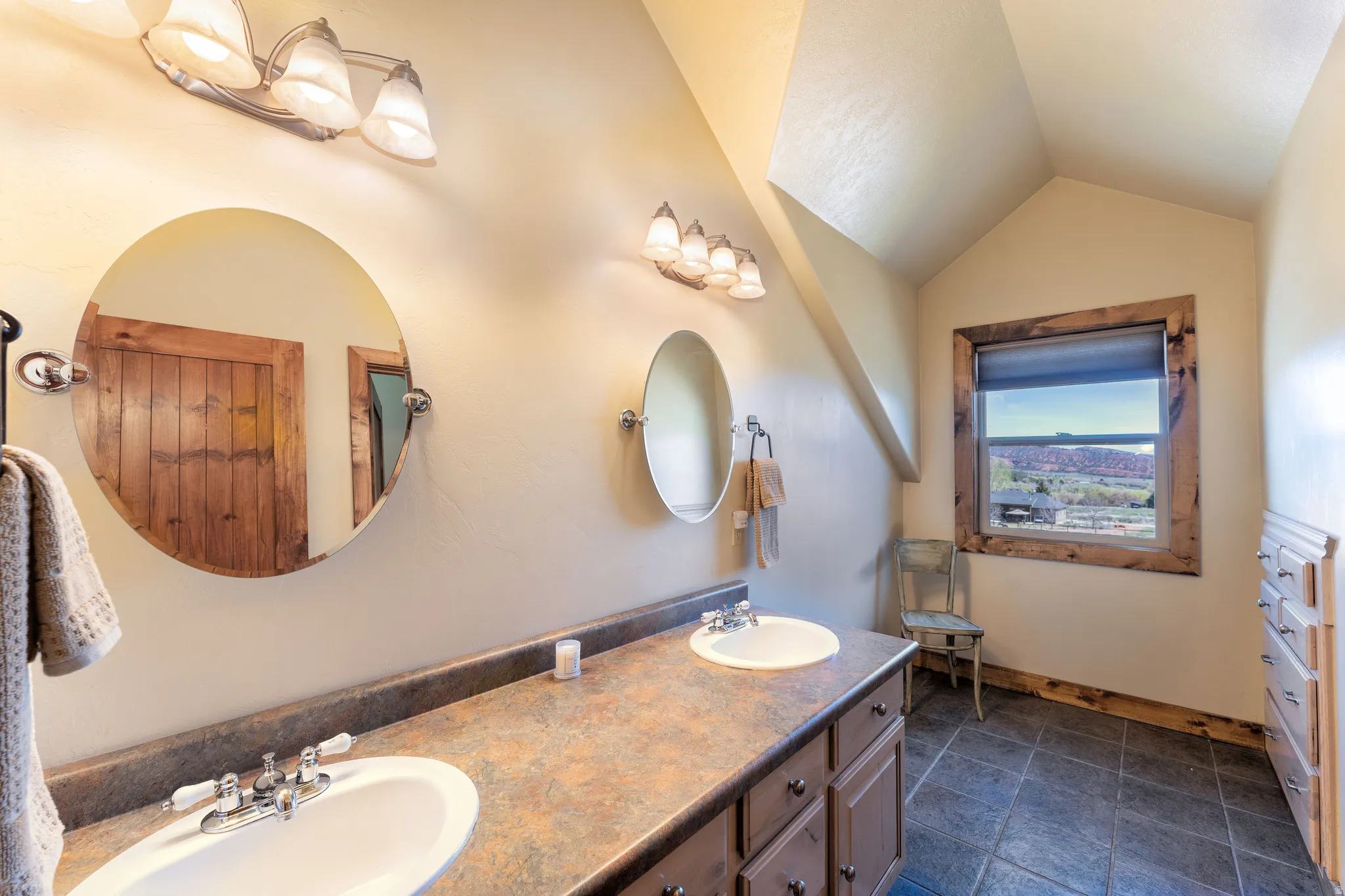 Bathroom featuring double vanity and vaulted ceiling