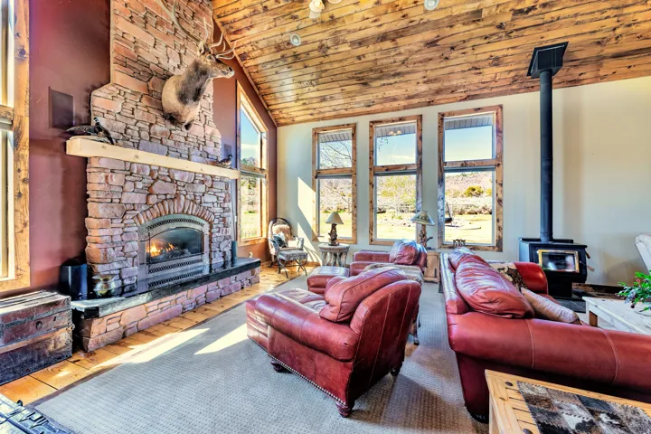 Living room with abundant natural light and featuring a rock gas fireplace floor to ceiling