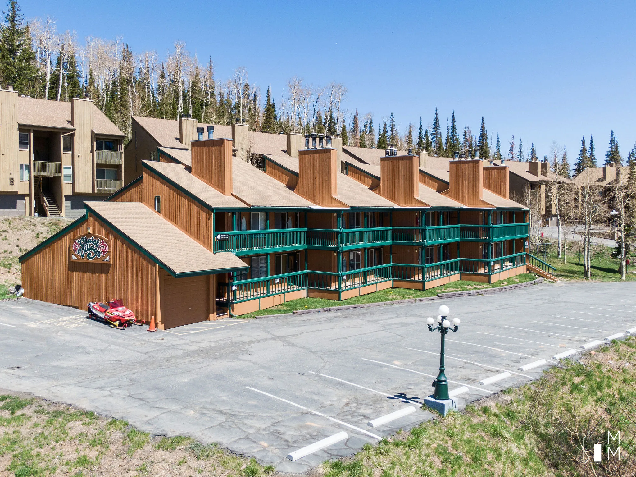 View of apartment building / complex featuring uncovered parking