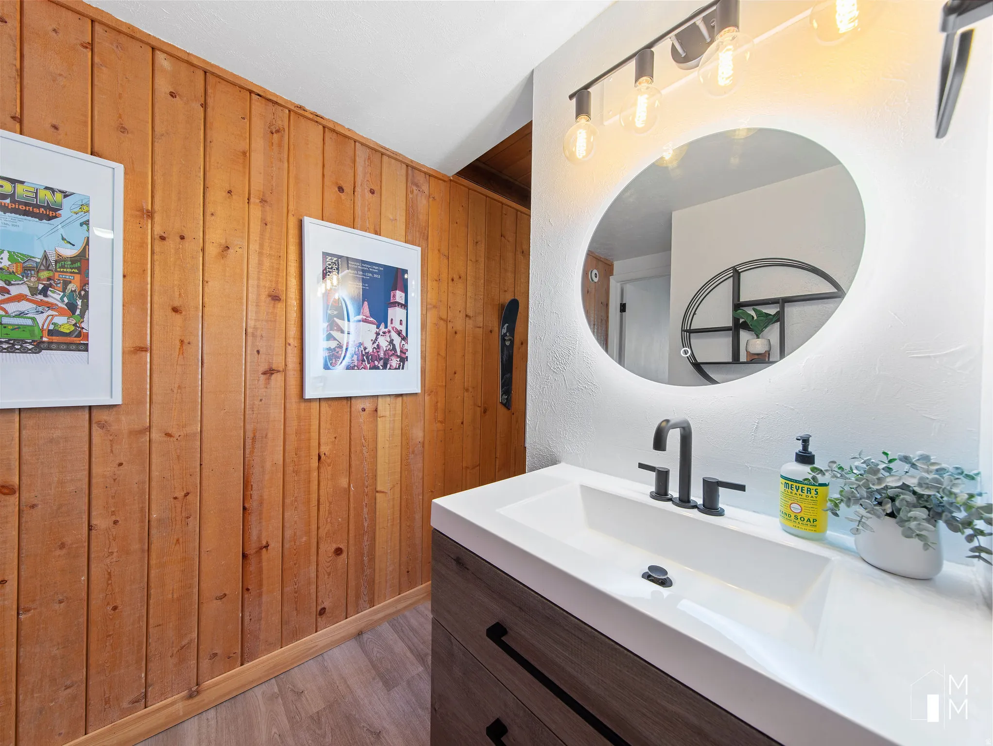 Bathroom featuring vanity, wood walls, and light wood-style flooring