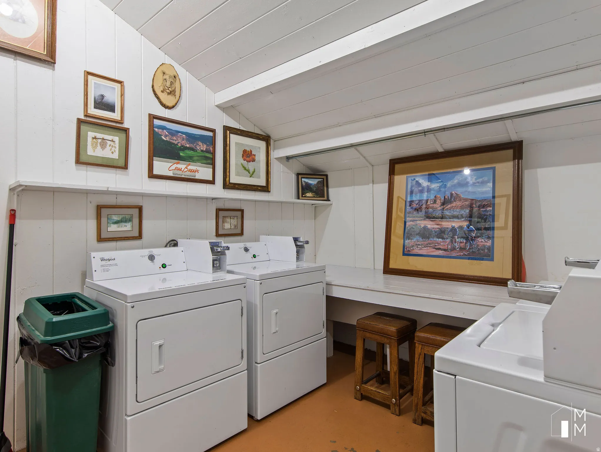 Shared laundry room featuring lofted ceiling, washer and dryer, and finished concrete floors