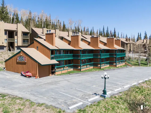 View of apartment building / complex featuring uncovered parking