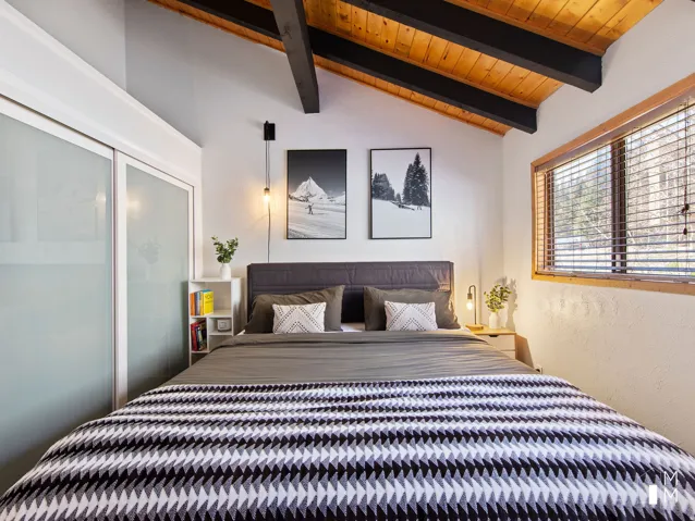 Bedroom with lofted ceiling with beams, a textured wall, and wooden ceiling