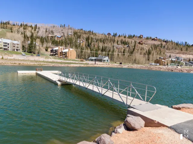 Dock area featuring a water view and a wooded view