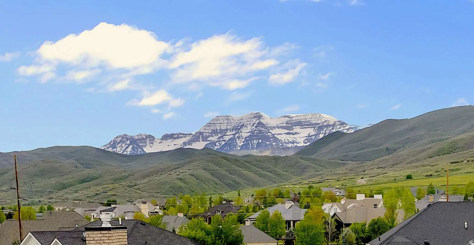 View of mountain backdrop featuring nearby suburban area